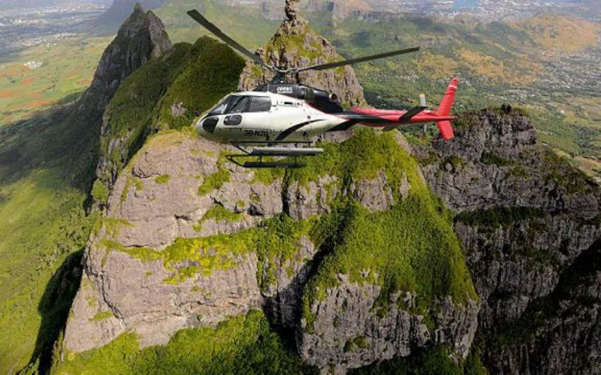 Un hélicoptère au-dessus d&rsquo;une crête verte escarpée dans l&rsquo;intérieur de l&rsquo;île
