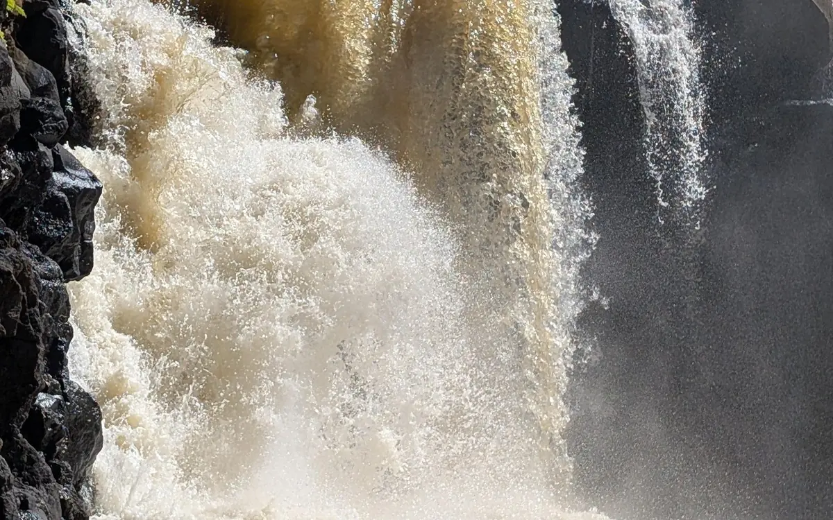 Veduta ravvicinata della cascata di Grand River South East che precipita bianca e bruna sul basalto scuro, con spruzzi sulla roccia