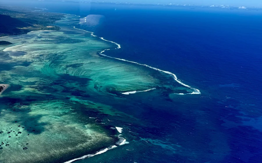 Les traînées de sable clair sur le rebord du plateau au large du Morne, vues du ciel